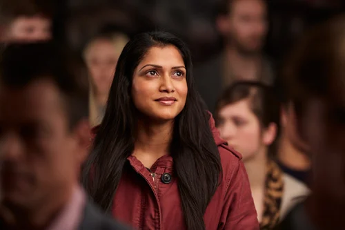 Woman in a maroon shirt looking optimistic 